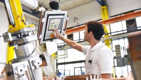 Arbeiter steuert die Herstellung von Transformatoren in einer Fabrik